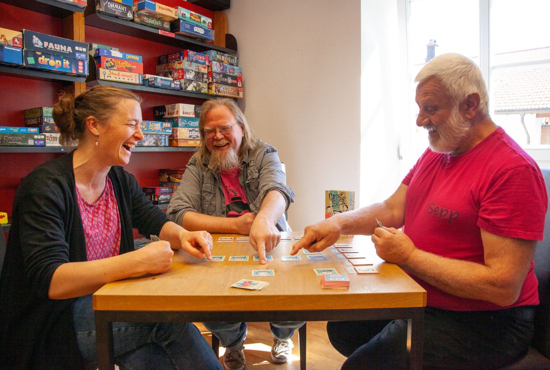 Lachende Spieler spielen ein Spiel in der Bücherei Grassau