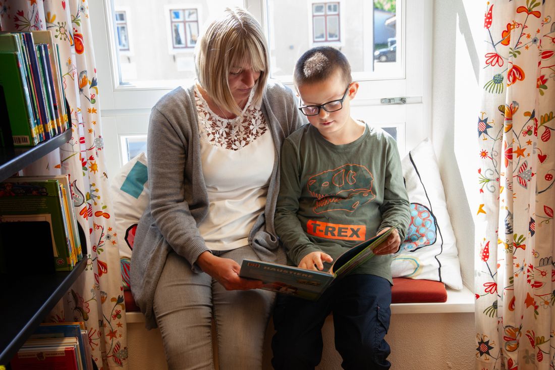 Mutter und Sohn schauen in ein Kindersachbuch