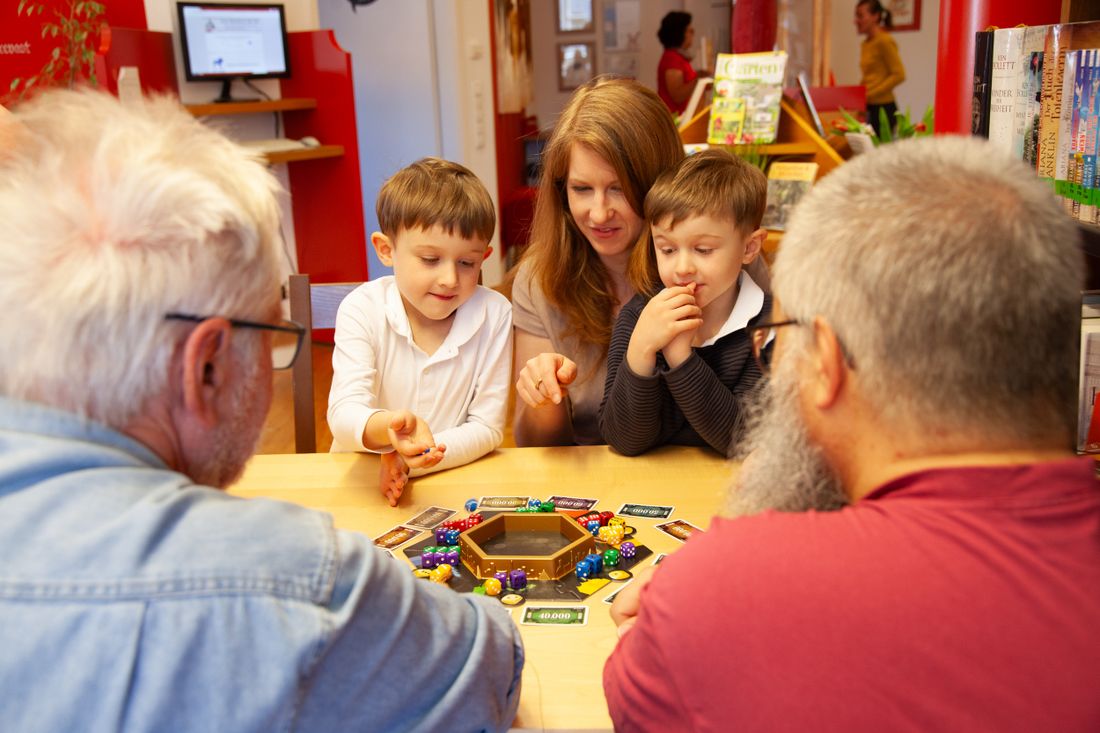 Gemeinsames Spielen von Gesellschaftsspielen in der Bücherei Grassau