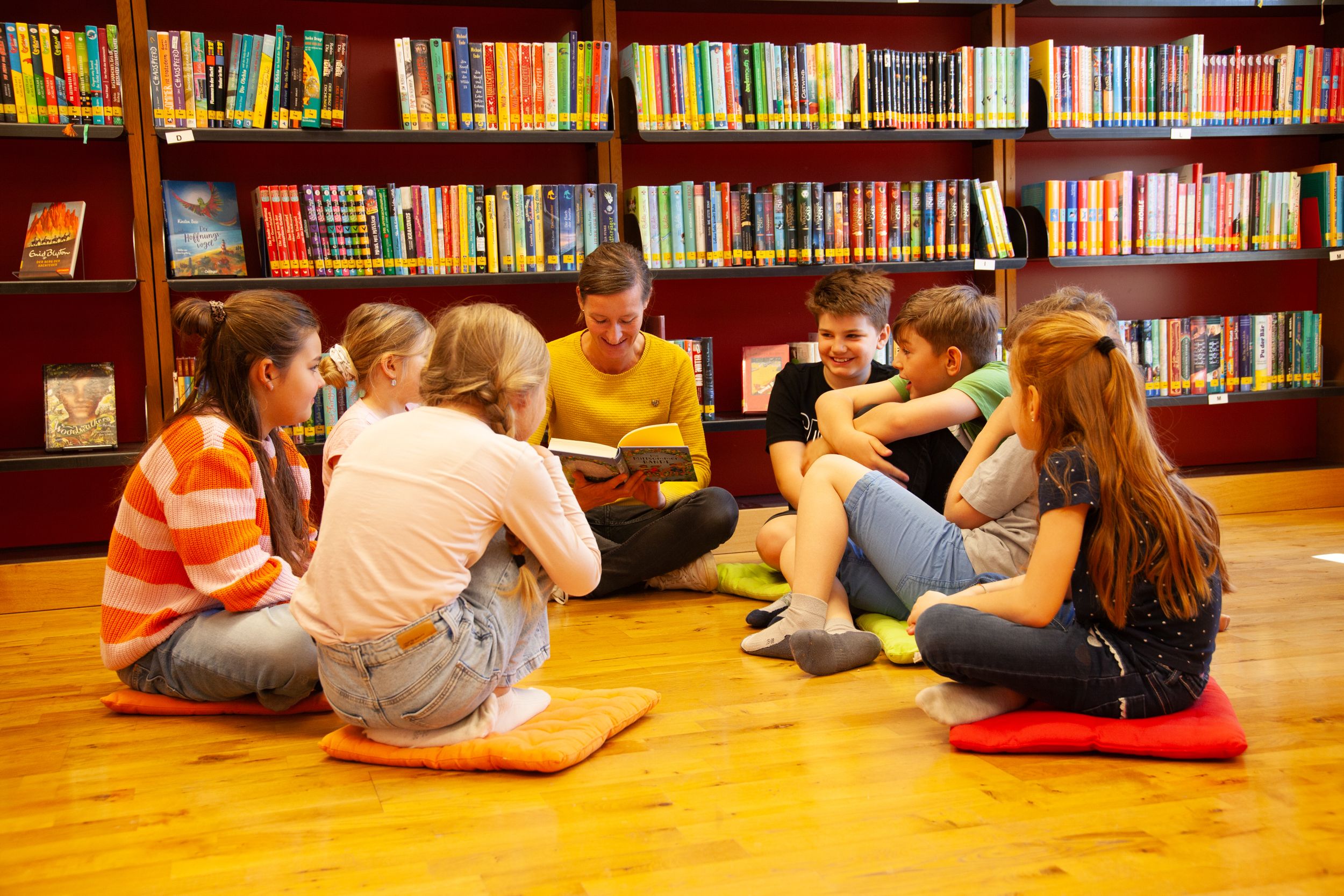 Mitarbeiterin der Bücherei Grassau mit einer Gruppe Kinder und Jugendlicher