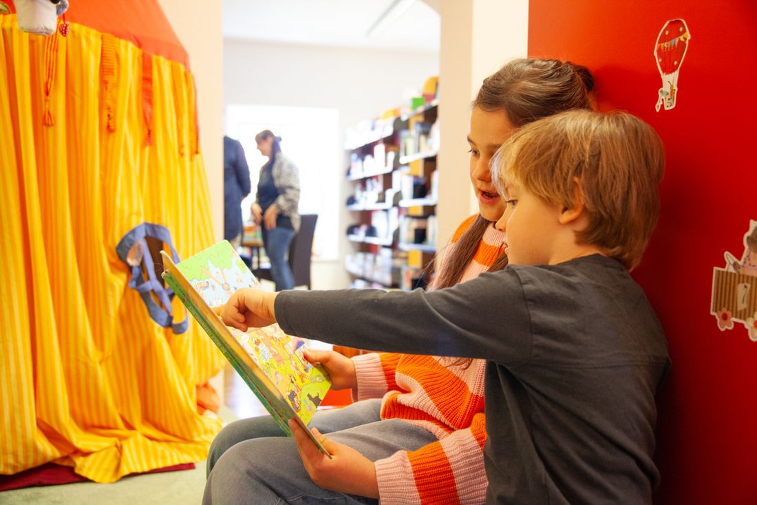 Zwei Kinder schauen in ein Kinderbuch