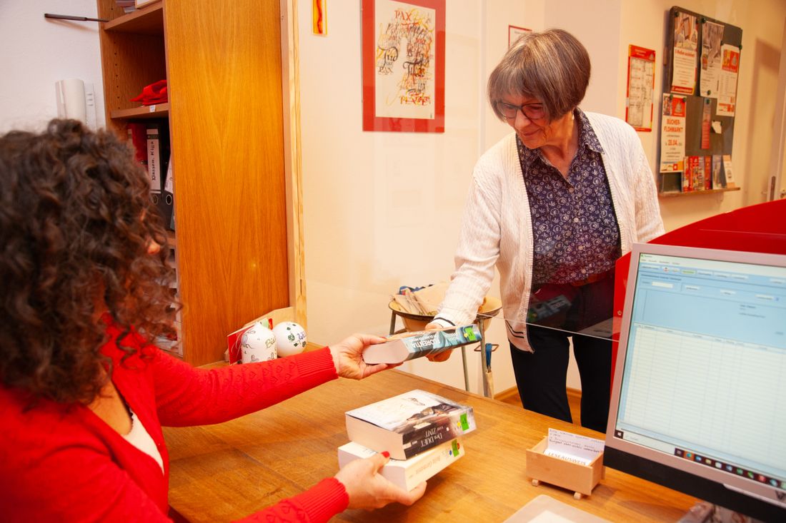 Mitarbeiterin und Kundin bei der Buchausleihe in der Bücherei Grassau