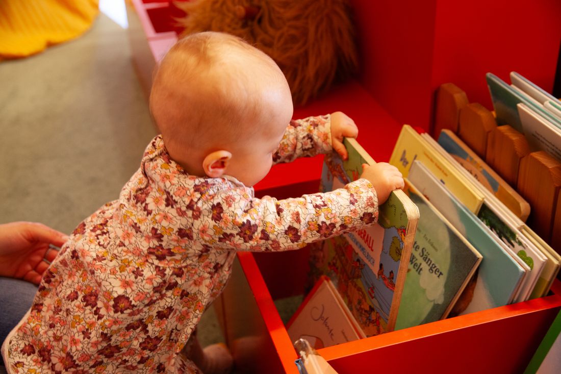 Kleinkind greift nach Kleinkinderbuch
